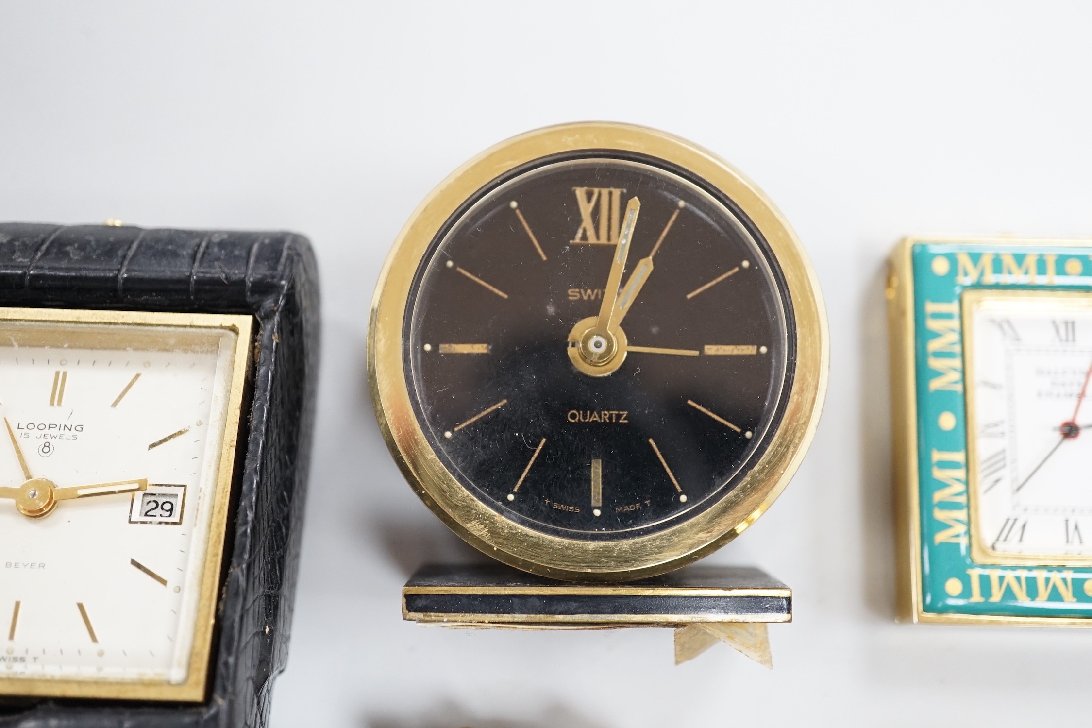 A Halcyon Days Harrods paperweight, a Halcyon Days timepiece and three other timepieces